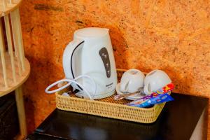 Ein Weidenkorb mit einem Teekessel und Tassen auf einem Tisch in der Unterkunft ภูธาราทรีเฮาส์แอทเชี่ยวหลาน Phutara Treehouses At Cheowlan in Ban Pha Saeng Lang