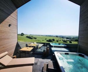 a patio with a hot tub and a table and chairs at La suite Hindi in Hollange