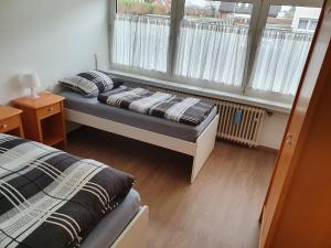 a bedroom with two beds and a window at Ferienwohnung Linden in Willich