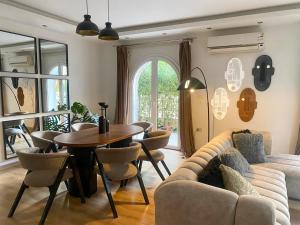a living room with a couch and a table at Elegant Hydepark Apt With Garden in New cairo +41 photos