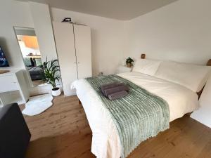 ein Schlafzimmer mit einem weißen Bett mit einer grünen Decke in der Unterkunft Perfect Family Home Enfield in Enfield