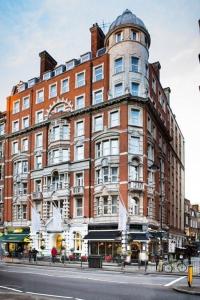 a large red brick building on a city street at voco London - Bloomsbury by IHG in London