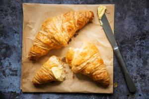 a group of croissants on a cutting board with a knife at Garner Hotel Lincoln by IHG in Lincoln