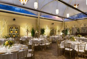 圣何塞Hotel de Anza by IHG的宴会厅配有桌椅、鲜花和蜡烛