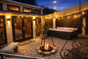 a backyard with a hot tub and a fire pit at Wellness Ferienwohnung mit Sauna, Massagen, Spa, beheizbarem Whirlpool bei Leipzig in Pomssen