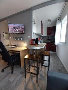 una cucina con scrivania, tavolo e sedie di Studio Beauséjour a Niort