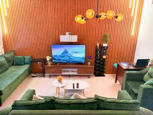 a living room with a couch and a flat screen tv at WAHA WOW Bed space Available in Luxury Apartment 101 in Sabkhah