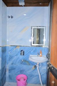 een badkamer met een blauwe muur en een wastafel bij Monishka Palace in Faizābād