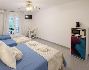 een kamer met 2 bedden en een keuken met een magnetron bij Alamos Hosteria in Mar Azul +54 foto's