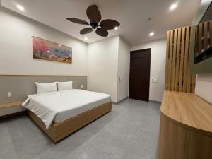 um quarto com uma cama e um ventilador de teto em Bacnam Quang Ngai Hotel em Kon Rung (1)