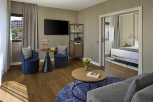 ein Hotelzimmer mit Bett und Wohnzimmer in der Unterkunft NH Madrid Ventas in Madrid