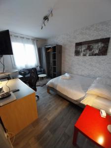 una camera da letto con un letto e una scrivania con un computer di Studio Beauséjour a Niort