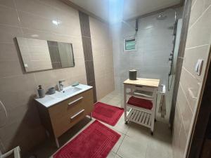 a bathroom with a sink and a shower with red mats at Ti' case la plaine in La Plaine des Palmistes +7 photos