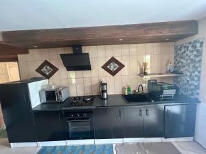a kitchen with a black counter top and a stove at Ti' case la plaine in La Plaine des Palmistes