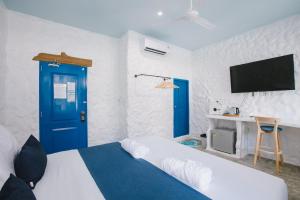 a room with a bed and a blue door and a tv at Sweett Lemon Home in Patong Beach +53 photos