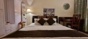 a bedroom with a large bed and a desk at The Moonvale Cottage A Victorian Theme Independent Homestay! in Chandīgarh