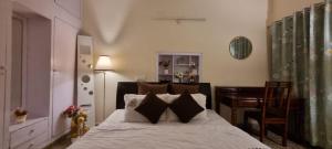 a bedroom with a bed with a desk and a table at The Moonvale Cottage A Victorian Theme Independent Homestay! in Chandīgarh