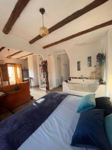 Un dormitorio con una cama grande y una bañera. en El Planeta Escondido, en Losana de Pirón
