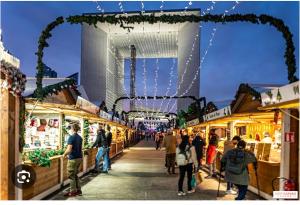 Eine Menschenmenge, die nachts durch einen Markt geht in der Unterkunft Charmant studio à Paris in Courbevoie