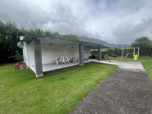 a house with a patio with chairs in a yard at Ti' case la plaine in La Plaine des Palmistes