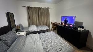 a bedroom with a bed and a flat screen tv at Greenwich Homestay in London