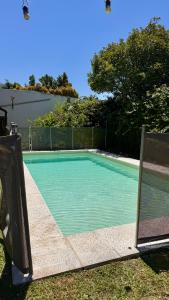 een zwembad in een tuin met een hek bij PH tipo casa, con parque y pileta, en La Plata , barrio norte in La Plata