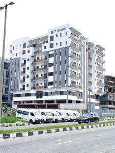 a large building with cars parked in front of it at Apex apartment in Ilado