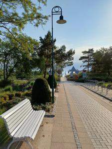 a white park bench next to a street light at Villa Christiane Wohnung 8 in Heringsdorf