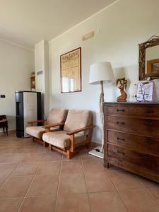 a living room with a couch and a lamp and a dresser at Pink House in Perdifumo