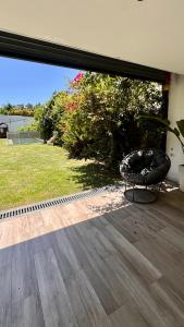 een grote glazen schuifdeur met een stoel op een terras bij PH tipo casa, con parque y pileta, en La Plata , barrio norte in La Plata