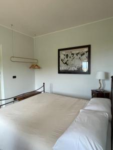 a bedroom with a bed and a picture on the wall at Pink House in Perdifumo