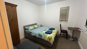 a small bedroom with a bed and a desk at Greenwich Homestay in London +8 photos