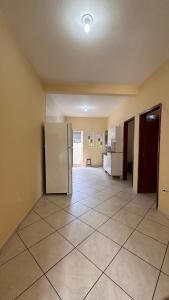 een keuken met een koelkast in het midden van een kamer bij Casa Guriri in São Mateus +10 foto's