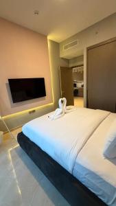 a large white bed in a room with a flat screen tv at Boulevard Sea View Luxury 1 BR Next Dubai Mall in Dubai +5 photos
