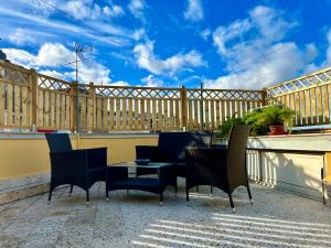 een terras met stoelen en een tafel op een balkon bij Casza me in Bronte