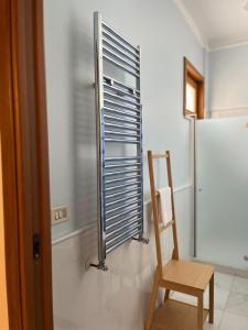 een houten stoel in een badkamer met een koelkast bij Casza me in Bronte +33 foto's