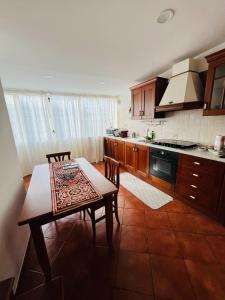 een keuken met een tafel en een tafel met stoelen bij Casza me in Bronte