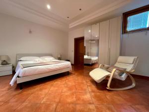 een slaapkamer met een bed en een stoel erin bij Casza me in Bronte