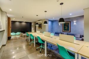 ein Konferenzraum mit einem langen Tisch und grünen Stühlen in der Unterkunft Estúdios no Centro Histórico de Poa - ELSs in Porto Alegre + 7 Fotos