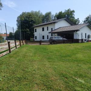 een wit huis met een hek en een tuin bij Ferienwohnung Casa Bianka Erdgeschoss in Fridolfing
