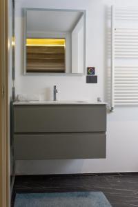 une salle de bains avec un lavabo et un miroir dans l'établissement ArtStay - Exclusive Apt Near Metro M1, AC, Parking, à Milan 24 autres photos