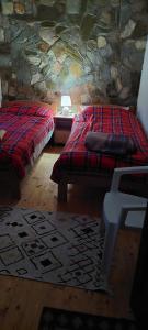 two beds in a room with a stone wall at Villla Gezve in Velmevci
