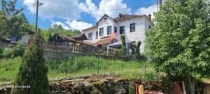 a white house on a hill with a fence at Villla Gezve in Velmevci