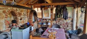 a kitchen with a table and a brick wall at Villla Gezve in Velmevci