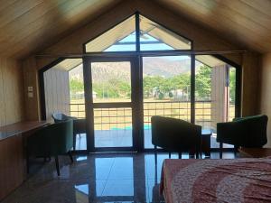 ein Zimmer mit einem Bett und einem großen Glasfenster in der Unterkunft Shivir Aranya - Wilderness Resort in Alwar