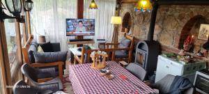 a living room with a table and a fireplace at Villla Gezve in Velmevci