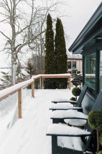een met sneeuw bedekt terras met stoelen op een huis bij Narrows Nook - Prince Edward County Waterfront in Deseronto