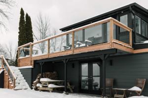 een huis met een terras rondom in de sneeuw bij Narrows Nook - Prince Edward County Waterfront in Deseronto +37 foto's