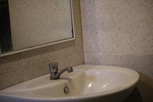 een witte wastafel in een badkamer met een spiegel bij Wilpattu Haritha Villa in Pahala Maragahawewa