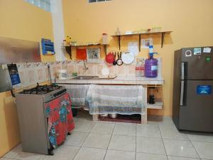a kitchen with a stove and a refrigerator at Hospedaje Piquero in Puerto Baquerizo Moreno